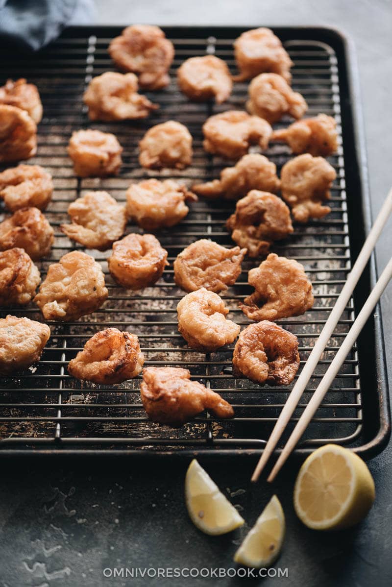 3-Ingredient Fried Shrimp is the easiest fried shrimp recipe that generates the best results. The juicy shrimp are wrapped in a light, crispy, and fluffy crust that is similar to tempura. So good! #seafood #recipes #shrimp Fried shrimp on cooking rack closeup