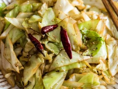 Infuse the oil with aromatics and then toss at a high heat, this adds a smoky flavor to the sweet fried cabbage and makes a quick and delicious side dish.