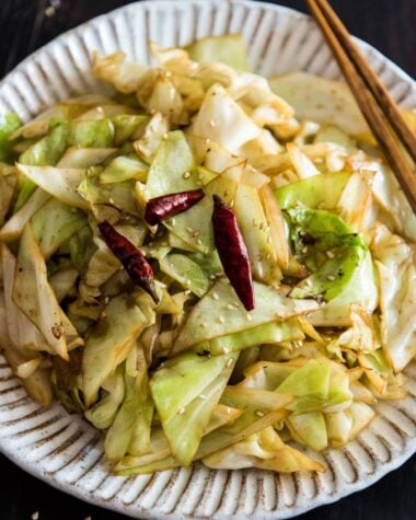 Infuse the oil with aromatics and then toss at a high heat, this adds a smoky flavor to the sweet fried cabbage and makes a quick and delicious side dish.