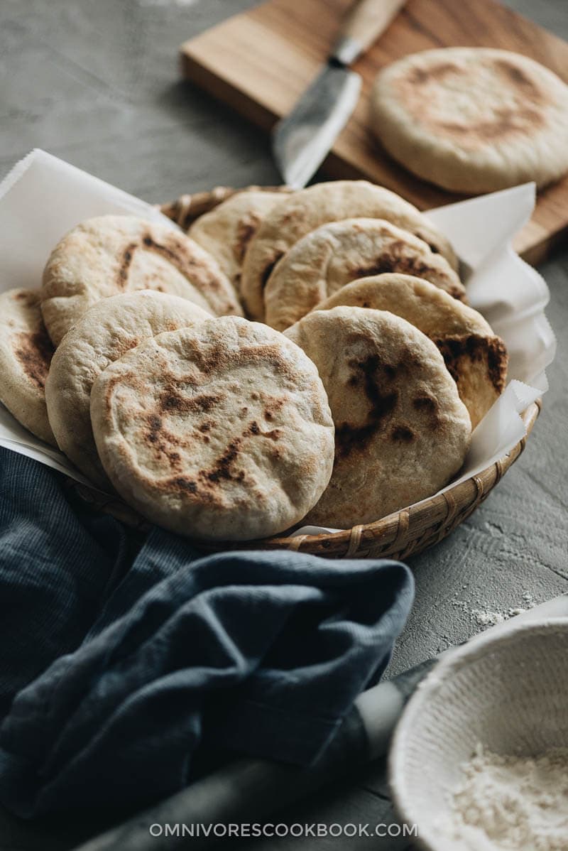 This super fast and easy flatbread recipe will totally blow your mind because it uses only 2 ingredients and 15 minutes of active cooking. You can use it to make pork belly buns or serve the bread with curry. So versatile! #vegetarian #vegan #bread #easy #recipes Close-up of a dozen flatbreads served in bamboo basket