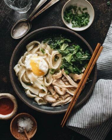 One bowl of Instant Pot chicken noodle soup with Sriracha and salt on the side