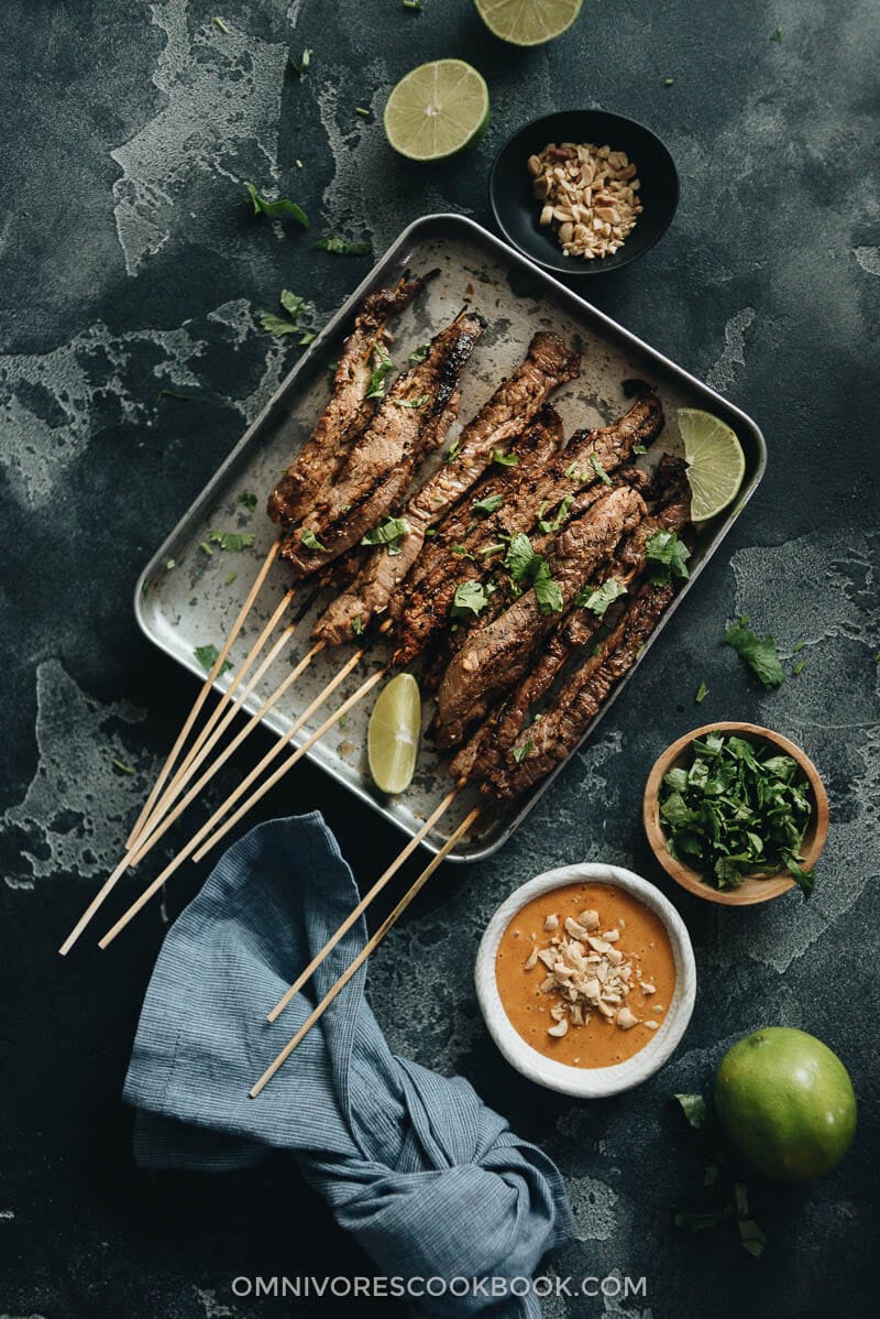 Beef Satay - Skewers of flavorful beef get that perfect char over the Chinese grill and are served with a sweet, tangy and totally craveable peanut sauce. #marinade #recipe #sticks #gluten-free Beef satay served with peanut sauce and cilantro