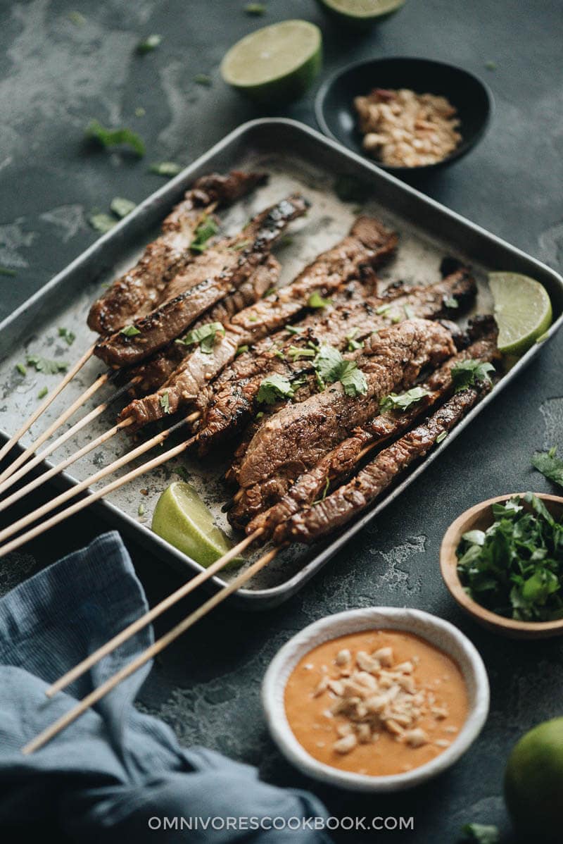 Beef Satay - Skewers of flavorful beef get that perfect char over the Chinese grill and are served with a sweet, tangy and totally craveable peanut sauce. #marinade #recipe #sticks #gluten-free Grilled beef satay served on a tray