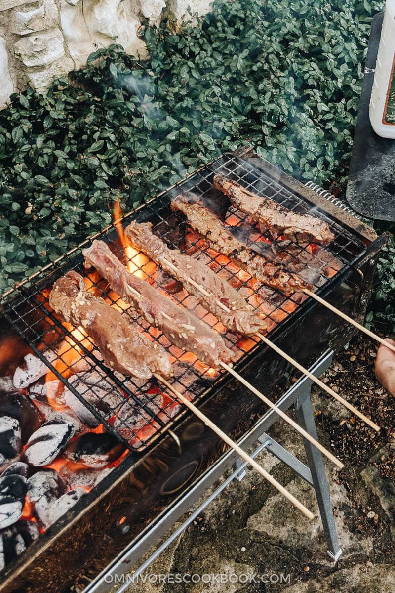 Beef Satay - Skewers of flavorful beef get that perfect char over the Chinese grill and are served with a sweet, tangy and totally craveable peanut sauce. #marinade #recipe #sticks #gluten-free Grilling beef satay on a Chinese grill