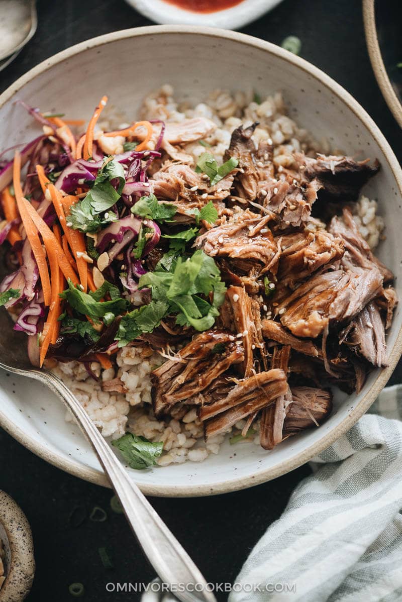 Asian-Style Instant Pot Pulled Pork - Tender, juicy pork with a melt-in-your-mouth texture made in a rich Asian sauce. It’s just about everything you need for a weekday dinner because it takes no time to put together. #easy #glutenfree #recipe #shoulder Asian Instant Pot pulled pork served on steamed brown closeup