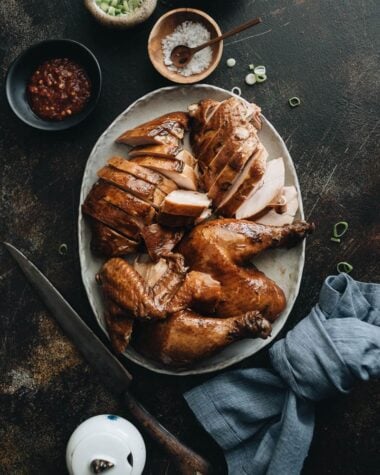 Sliced soy sauce chicken served with Sriracha, salt, and green onions