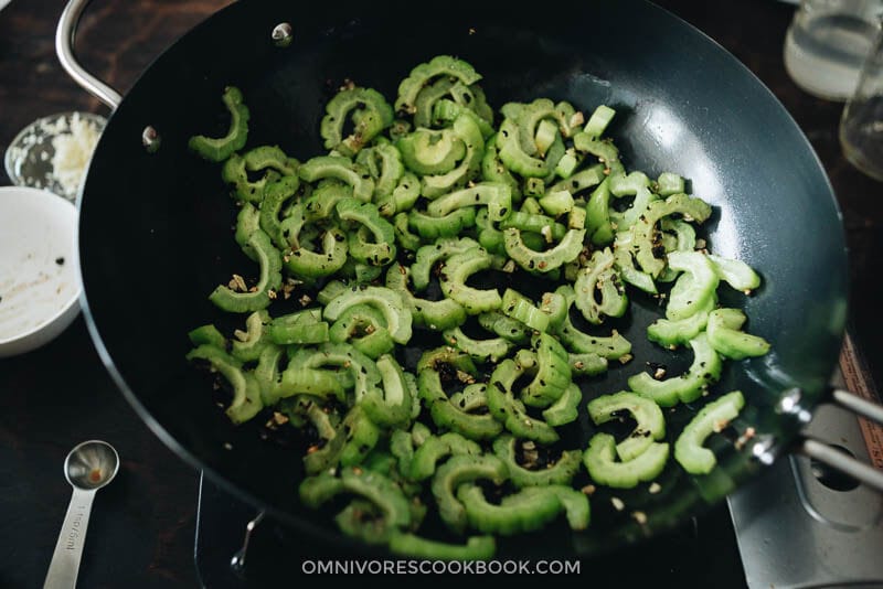 Stir Fried Bitter Melon with Fermented Black Beans - This quick, tasty, and healthy side dish will surprise you with its beautiful simplicity and rich flavor. #glutenfree #chinese #healthy Cooking stir fried bitter melon in a wok