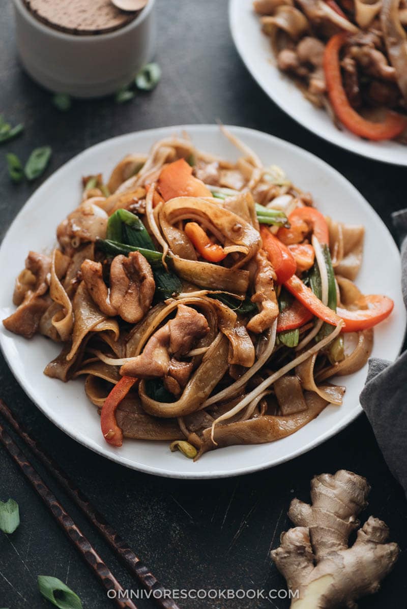 15-Minute Chicken Chow fun - This chicken fried noodle recipe is super fast to make and yields restaurant-style results. The dish is loaded with fat rice noodles, tender chicken, and crisp veggies. No wok required! #recipe #comfortfood #stirfry #glutenfree Restaurant style chicken chow fun close up