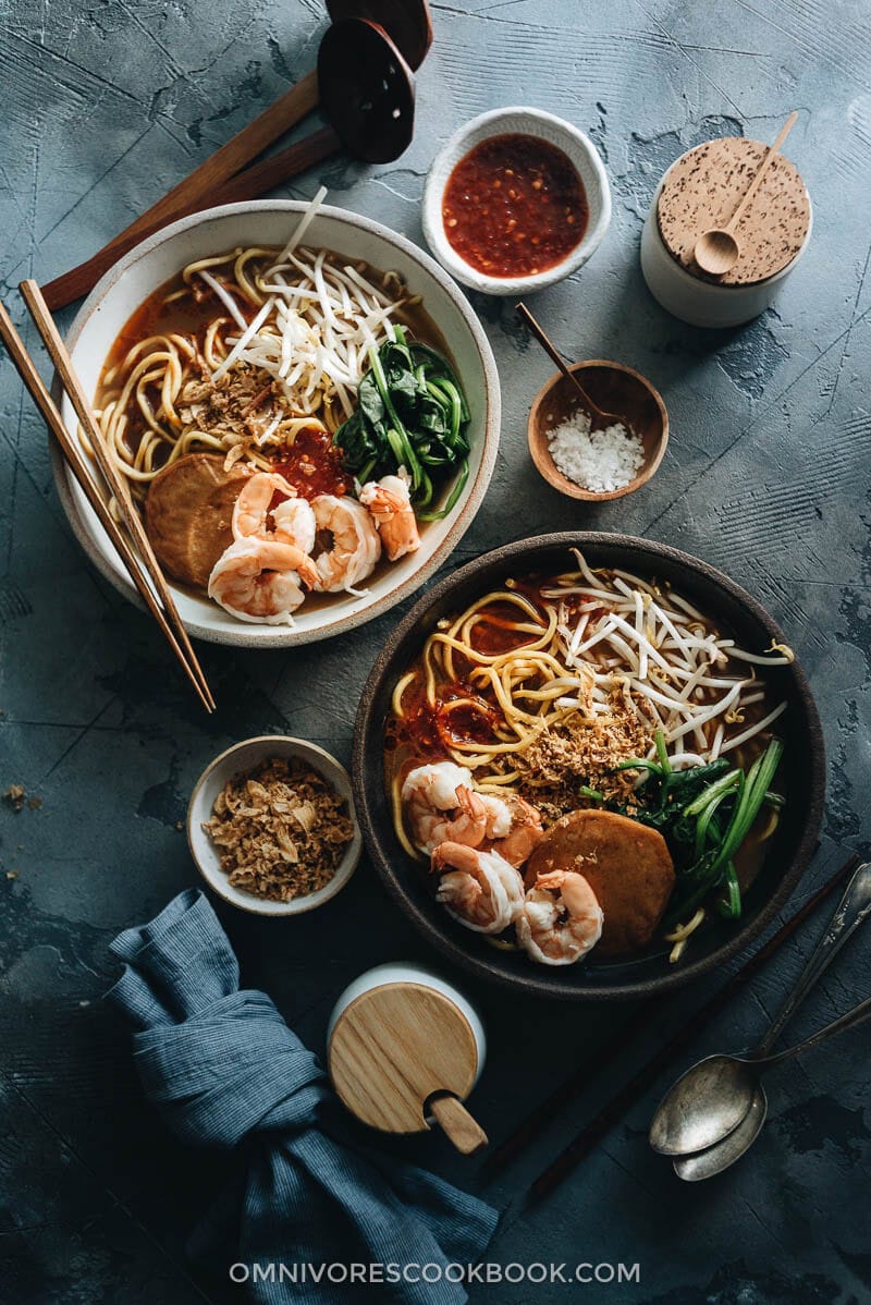 Hokkien Prawn Mee Noodle Soup (Hae Mee) - Tender yellow noodles in a rich savory-sweet red-orange broth served with juicy prawns, fish cakes, crunchy bean sprouts, and crispy fried shallots. {Gluten-Free adaptable} Hokkien Prawn Mee Noodle Soup (Hae Mee) served in bowls, with sambal sauce and fried shallots on the side