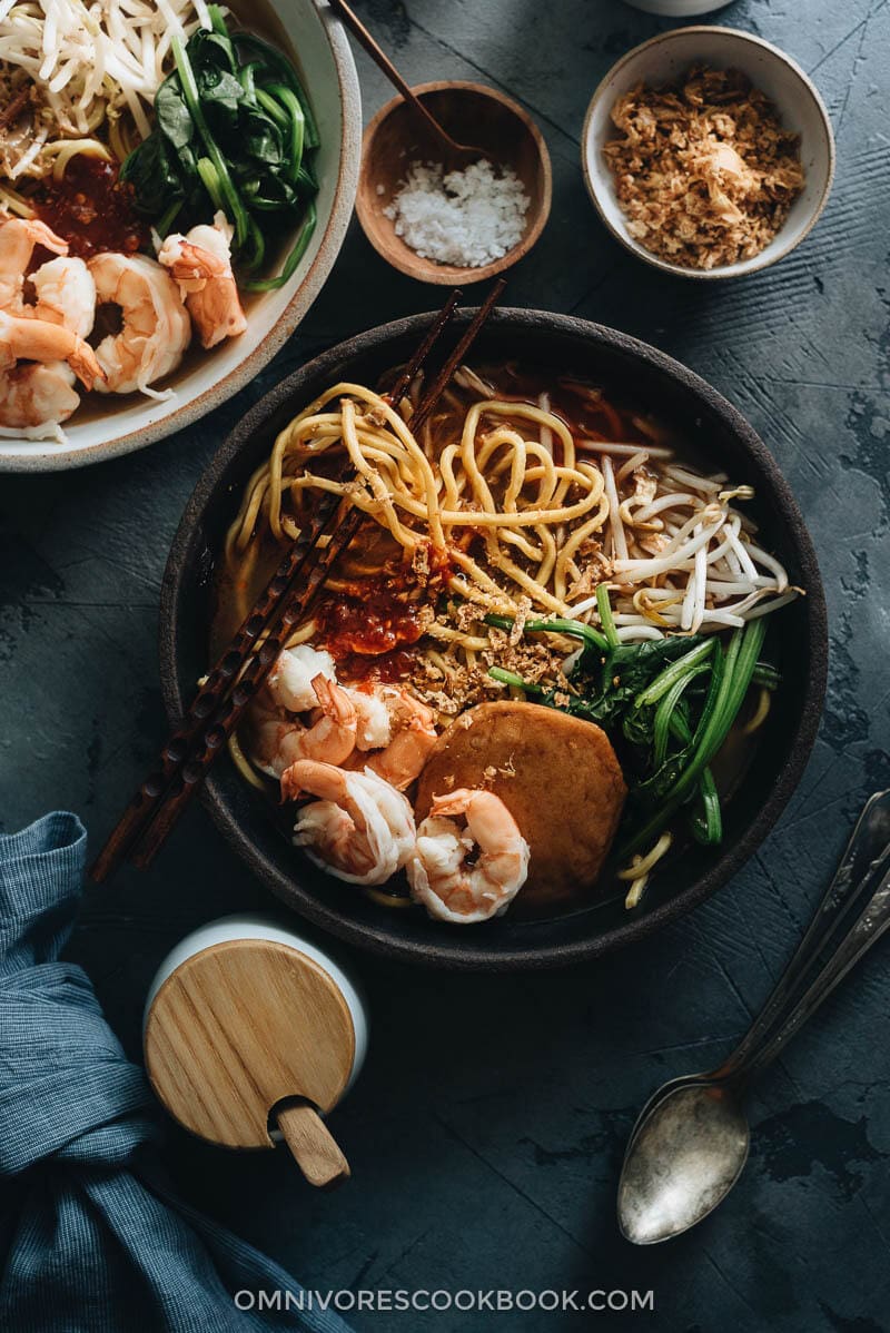 Hokkien Prawn Mee Noodle Soup (Hae Mee) - Tender yellow noodles in a rich savory-sweet red-orange broth served with juicy prawns, fish cakes, crunchy bean sprouts, and crispy fried shallots. {Gluten-Free adaptable} Hokkien Prawn Mee Noodle Soup (Hae Mee) garnished with sambal and fried shallots