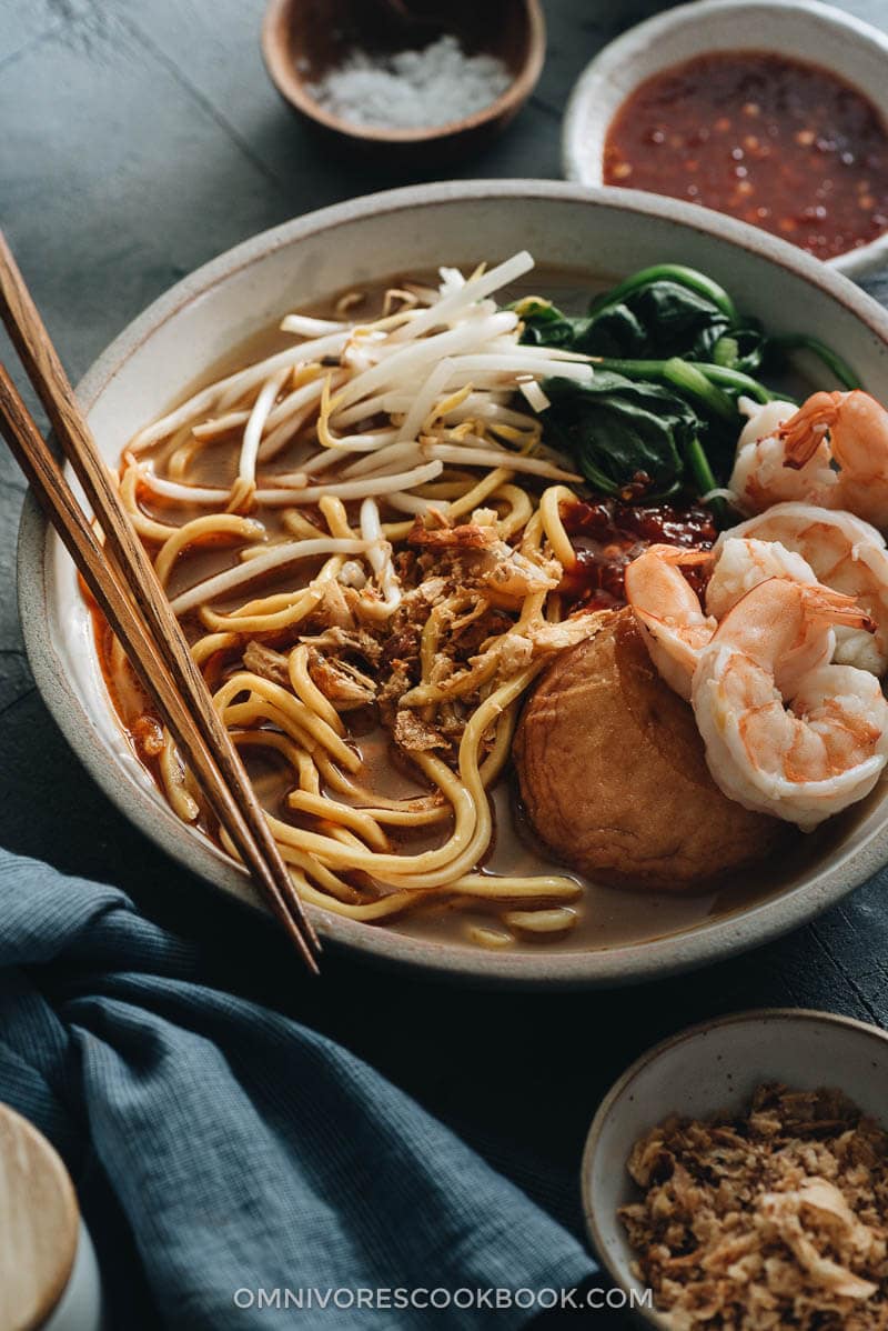 Hokkien Prawn Mee Noodle Soup (Hae Mee) - Tender yellow noodles in a rich savory-sweet red-orange broth served with juicy prawns, fish cakes, crunchy bean sprouts, and crispy fried shallots. {Gluten-Free adaptable} Hokkien Prawn Mee Noodle Soup (Hae Mee) topped with shrimp, fish cake, bean sprouts, and spinach