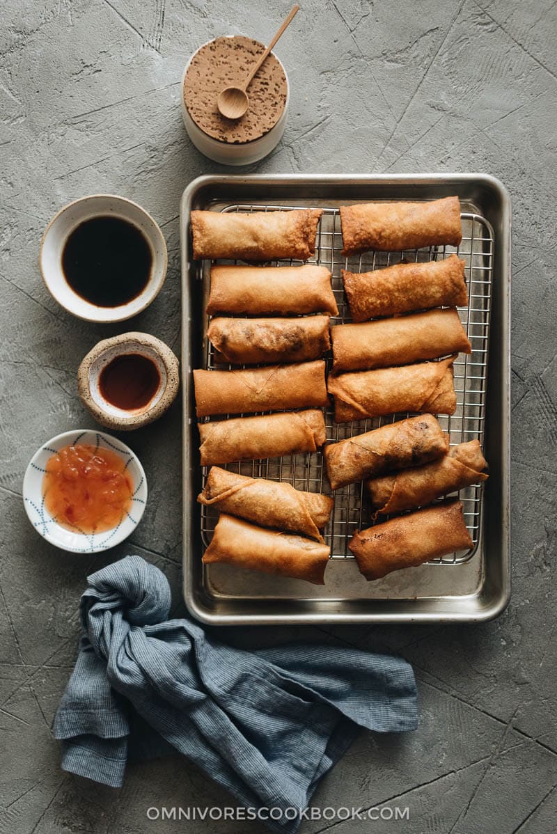 Chinese egg rolls - The ultimate guide to making restaurant-style egg rolls at home. These Chinese egg rolls are filled with tender meat and crunchy vegetables. I’ve included three cooking methods in this recipe and all of them yield a very crispy crust. Make them ahead and serve them as an appetizer at your dinner party or as a snack. #dimsum #takeout Fried Chinese egg rolls on cooling rack