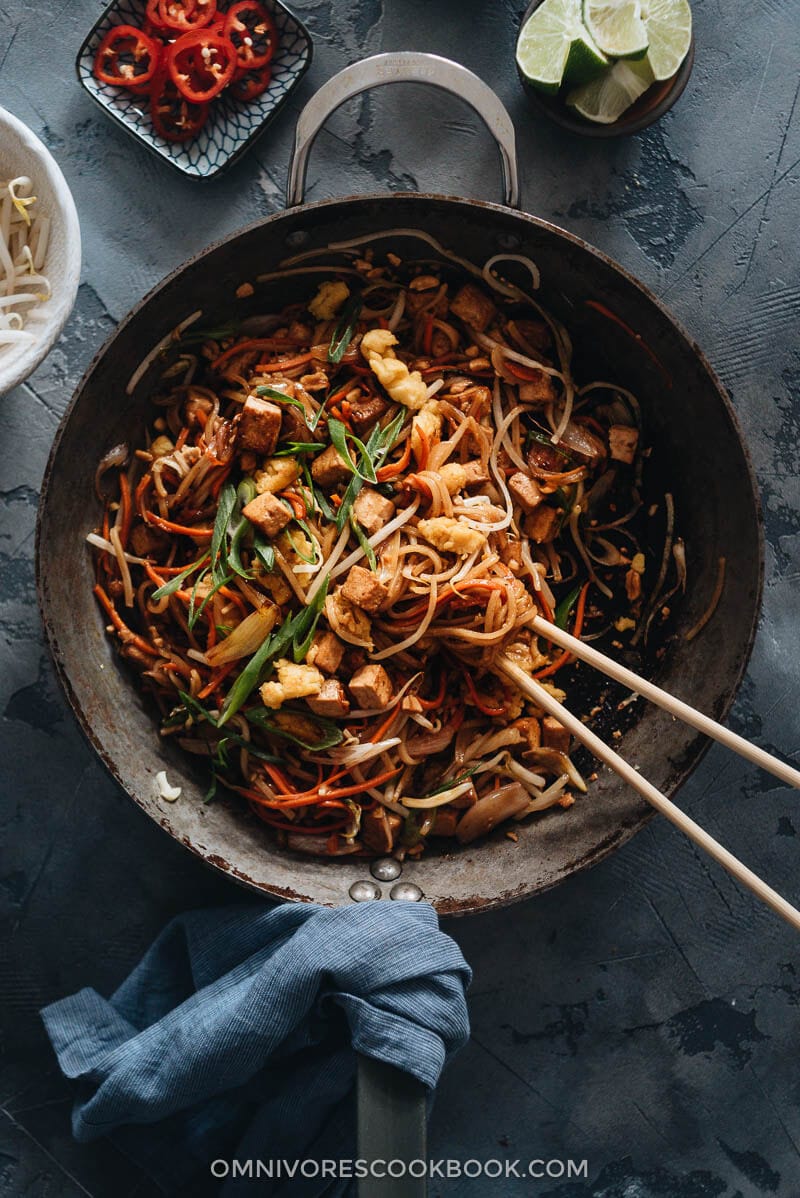 Vegan Pad Thai - The fat noodles are stir-fried with plenty of aromatics, veggies, vegan eggs, and marinated tofu in an extra rich sweet and sour sauce. Detailed cooking notes are included to guarantee you a great result that tastes even better than the restaurant version. {Gluten-Free adaptable} Homemade vegan Pad Thai in a pan