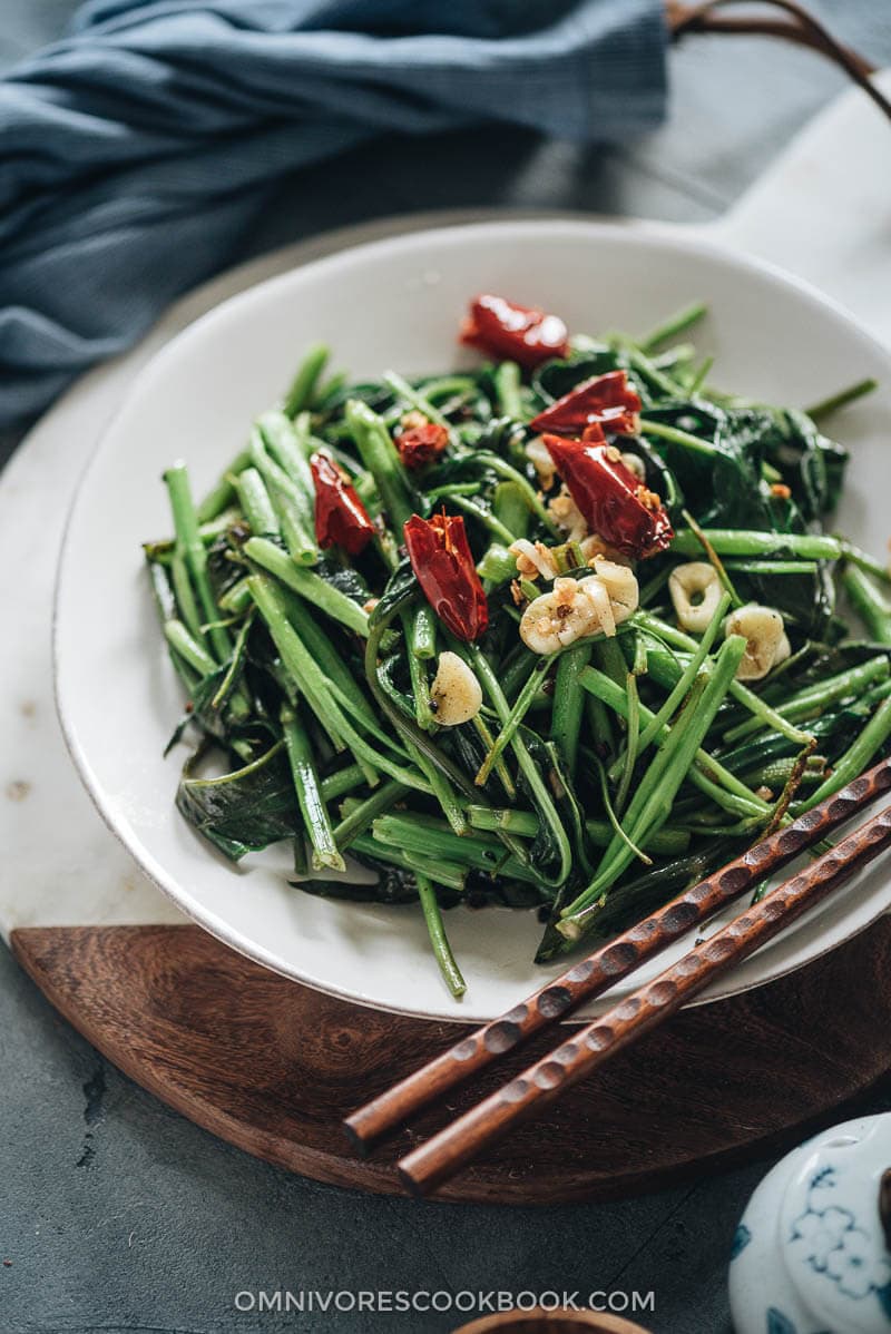 Stir-Fried Water Spinach - Two Ways | Introducing two ways to cook stir-fried water spinach, and both require fewer than five ingredients. Try out this Chinese leafy green to add color and nutrition to your dinner table. {Vegan, Gluten-Free} Stir fried water spinach served on a plate