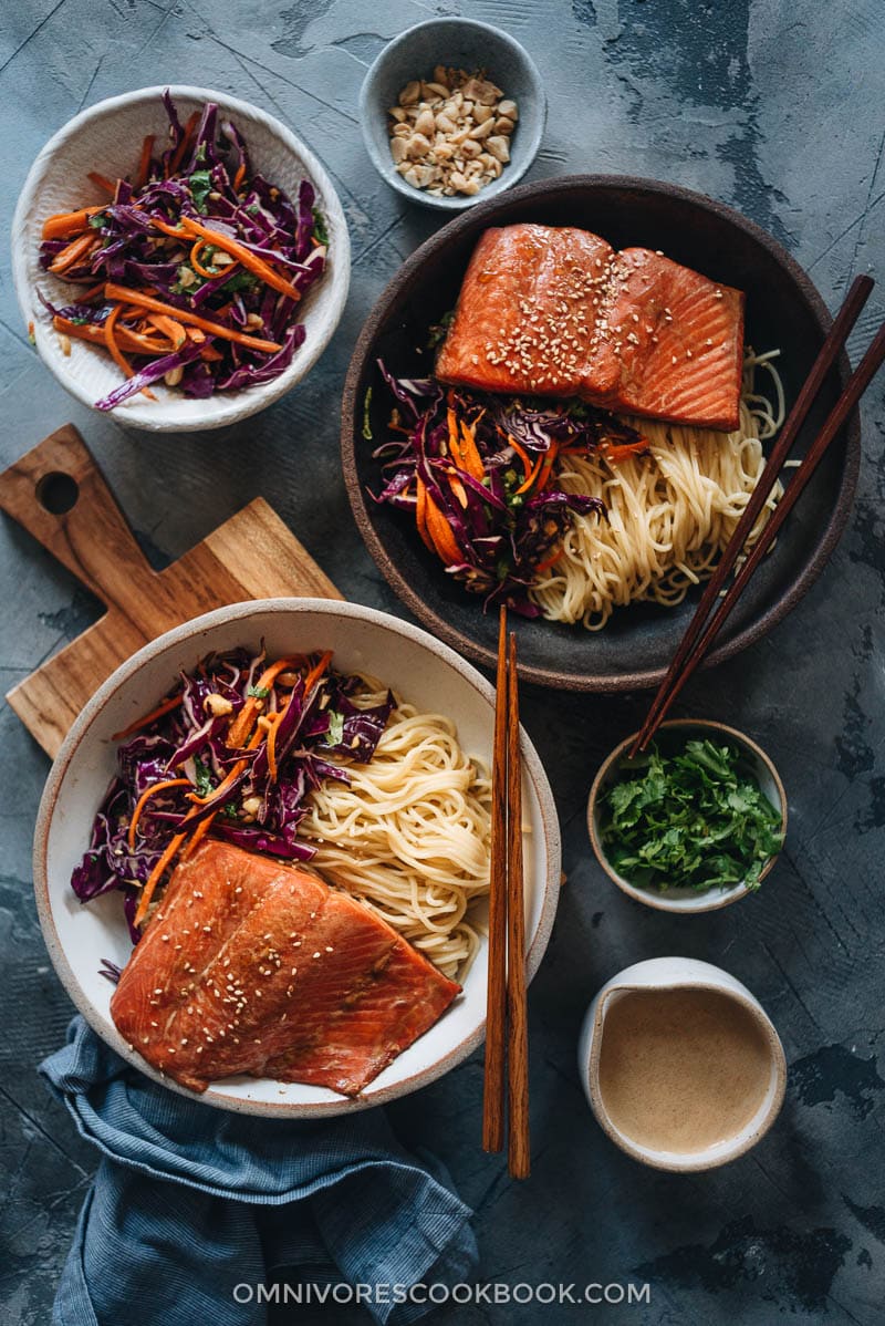 30-Minute Salmon Noodle Bowl with Coleslaw - Tender flaky juicy baked salmon served on noodles with coleslaw in a garlicky gingery savory sauce that’s lightly sweet. This recipe uses a blender to mix one sauce that is used as the salmon marinade and in the noodle sauce, so it literally takes 10 minutes to get ready. It’s a perfect dish for your busy weekday dinners and meal-prep. {Gluten-Free Adaptable} Salmon noodle bowl with coleslaw and sauce on the side