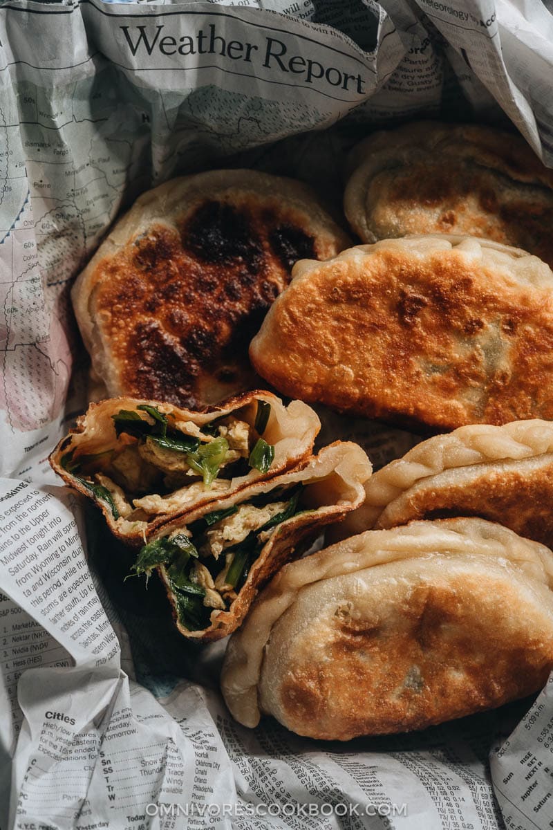 Chinese Chive Pockets (韭菜盒子, Chinese Chive Dumplings) | The super crispy and thin dough is stuffed with a hearty, savory filling made with Chinese chives and scrambled eggs. They’re easier to make than potstickers and have all the goodness that dumplings have, only more satisfying! Chinese chive pockets cut open revealing the filling