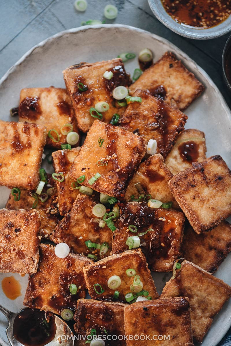 Crispy Marinated Tofu | This recipe generates the most flavorful marinated tofu! The tofu pieces are soaked in a savory spicy Asian sauce, then pan fried until crispy. It’s very easy to put together and yields crispy tofu bites that are bursting with flavor! {Vegan, Gluten-Free adaptable} Crispy fried tofu closeup