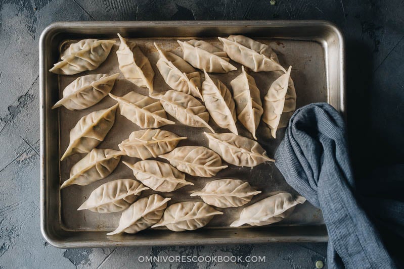 Turkey dumplings (A Thanksgiving Leftover Recipe) | Turn Thanksgiving leftovers into fancy dim sum using this turkey dumpling recipe. It uses leftover mashed potatoes, turkey, and cranberry sauce to make crispy, hearty, and juicy dumplings that are even better than takeout. Uncooked dumplings in a tray