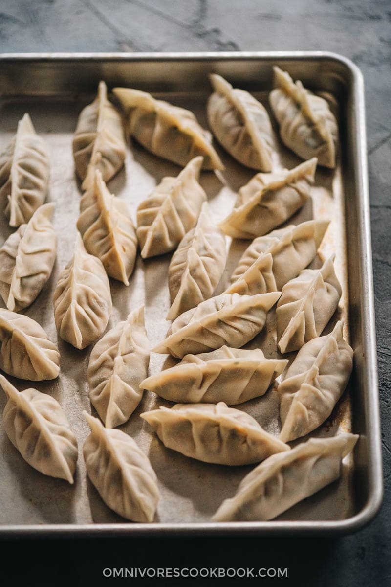 Turkey dumplings (A Thanksgiving Leftover Recipe) | Turn Thanksgiving leftovers into fancy dim sum using this turkey dumpling recipe. It uses leftover mashed potatoes, turkey, and cranberry sauce to make crispy, hearty, and juicy dumplings that are even better than takeout. Uncooked dumplings in a tray close-up
