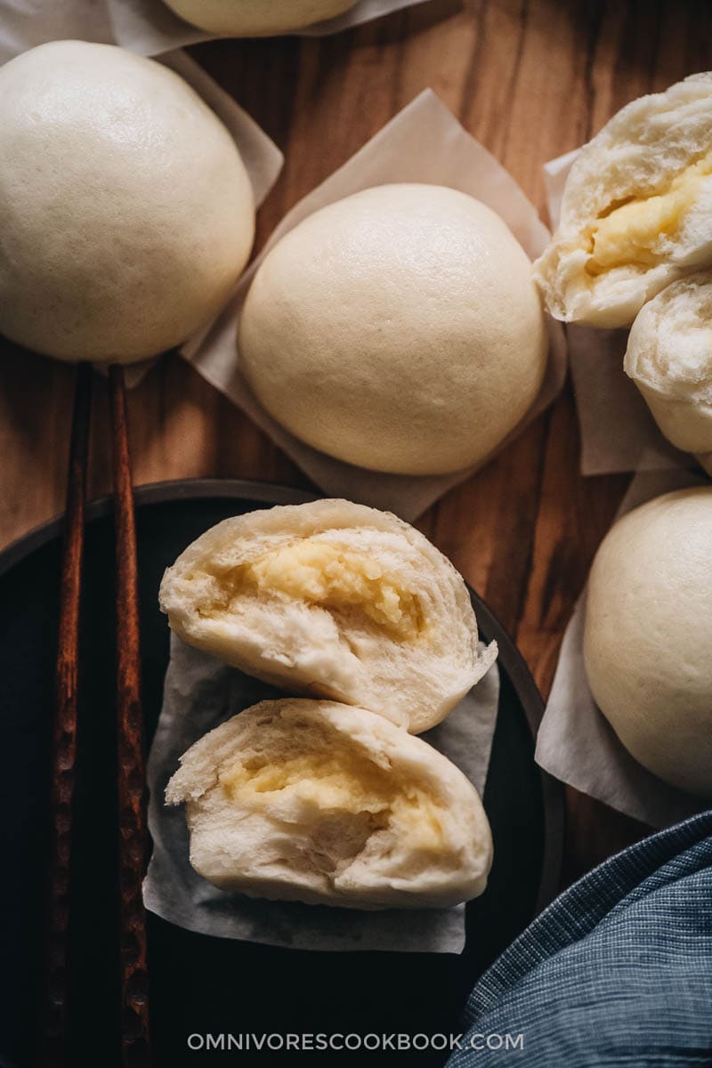 Chinese Steamed Custard Buns (nai wong bao, 奶黄包) | A dim sum classic, these buns are perfect for holiday gatherings and parties as well. Made with a yeast dough and steamed, the buns have a super soft and spongy texture with a smooth surface. The custard filling is creamy, fragrant, and sweet. The recipe includes detailed step-by-step pictures to help you recreate the restaurant-style custard buns in your own kitchen. Chinese steamed custard buns close-up