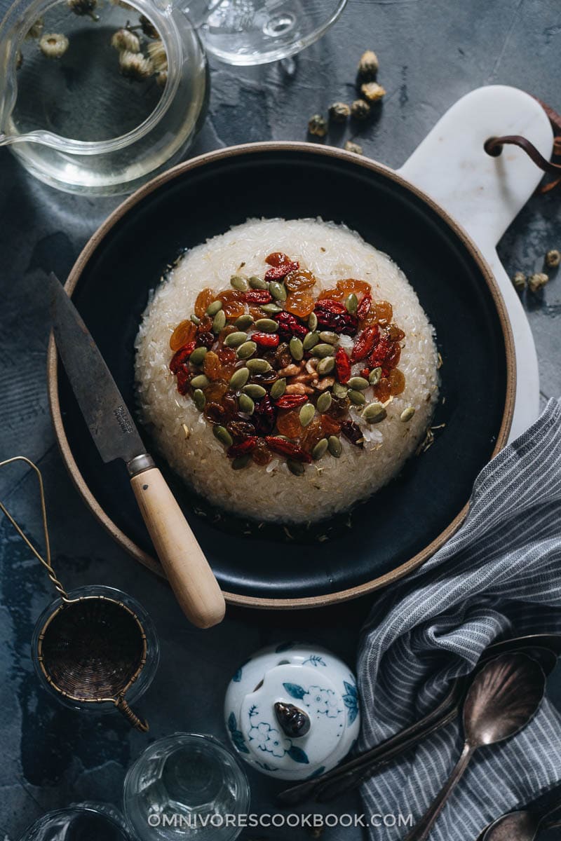 Eight Treasure Rice (八宝饭, Chinese Rice Pudding) | Lightly sweetened sticky rice stuffed with red bean paste and topped with dried fruits and seeds, then served with a fragrant chrysanthemum syrup that has an amazing earthy aroma. The modernized version tastes so good and uses ingredients that are easy to source. And the cooking is quite simple. It’s a light and healthy dessert that is perfect to serve at the end of a meal. {Vegan, Gluten-Free} Chinese eight treasure rice