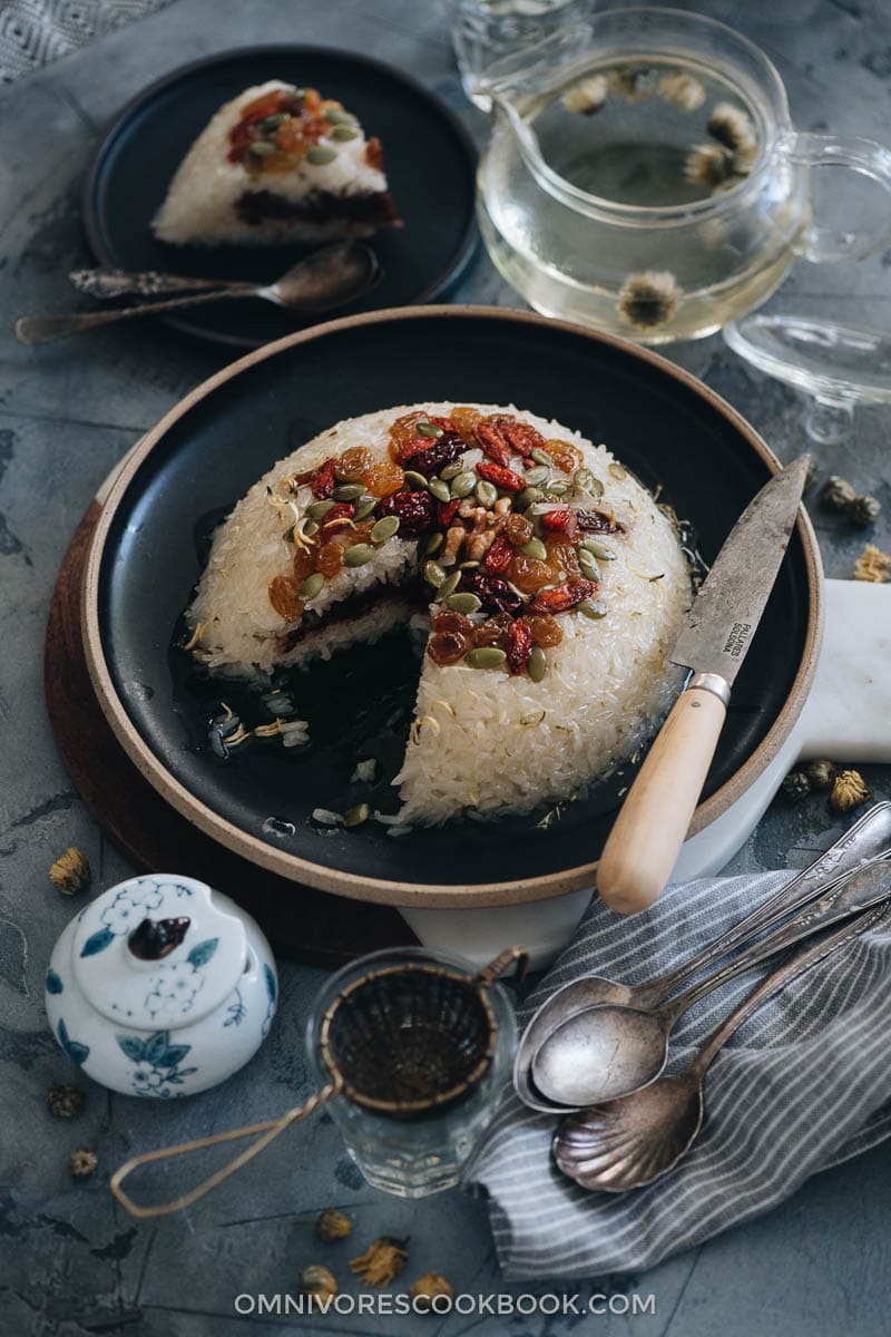 Eight Treasure Rice (八宝饭, Chinese Rice Pudding) | Lightly sweetened sticky rice stuffed with red bean paste and topped with dried fruits and seeds, then served with a fragrant chrysanthemum syrup that has an amazing earthy aroma. The modernized version tastes so good and uses ingredients that are easy to source. And the cooking is quite simple. It’s a light and healthy dessert that is perfect to serve at the end of a meal. {Vegan, Gluten-Free} Sliced eight treasure rice with red bean paste