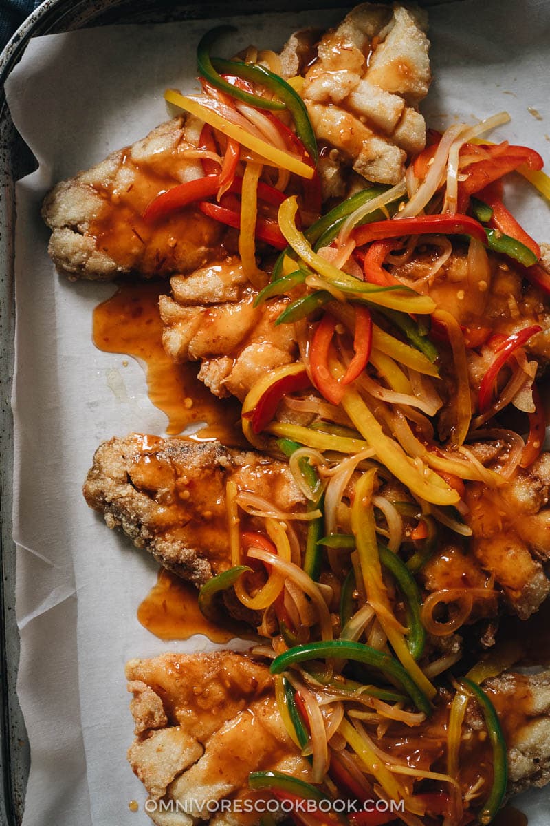 Sweet and sour fish fillets with peppers and onions on top