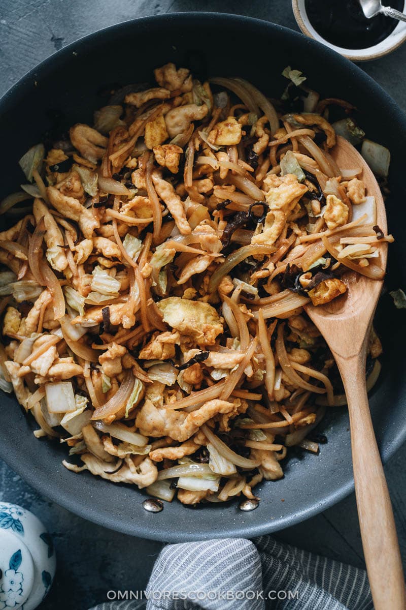 Moo Shu Chicken | A hybrid of authentic Chinese and American Chinese food, moo shu chicken makes a refreshing and delicious dish that’s better than the Chinese restaurant version. Tender juicy chicken, crisp napa cabbage, crunchy bamboo shoots, and wood ear mushrooms are quickly cooked in a savory and lightly sweet sauce. Serve either with moo shu wrappers or steamed rice and you’ll have a healthy and delicious meal. Homemade moo shu chicken in a pan