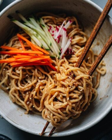 Chinese noodles in a bowl with sesame sauce and vegetables