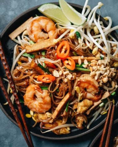 Easy shrimp fried noodles with egg and tofu, peanuts, chili pepper, and lime