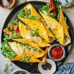Ji Dan Bing, or Chinese breakfast pancake, is a thin flour pancake cooked with a slightly scrambled egg, green onion and sesame, brushed with a sweet savory sauce. Top it with lettuce, veggies or bacon so it contains all of your favorite breakfast items in one wrap! It’s easy to put together, super hearty to eat, and beautiful to the eye