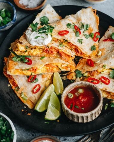 Egg and kimchi quesadilla served with lime, sour cream and salsa