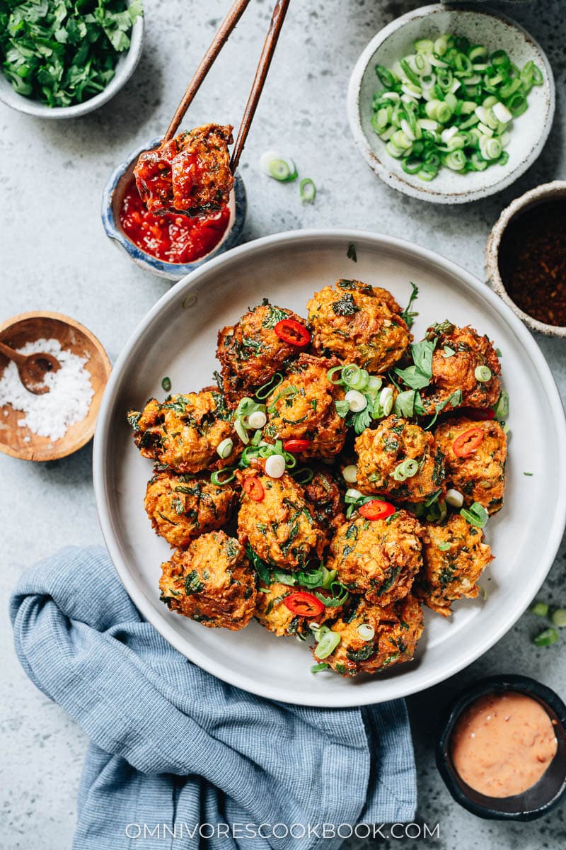 Dipping carrot fritter in the sauce
