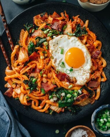 Korean fried noodles with kimchi, bacon and kale