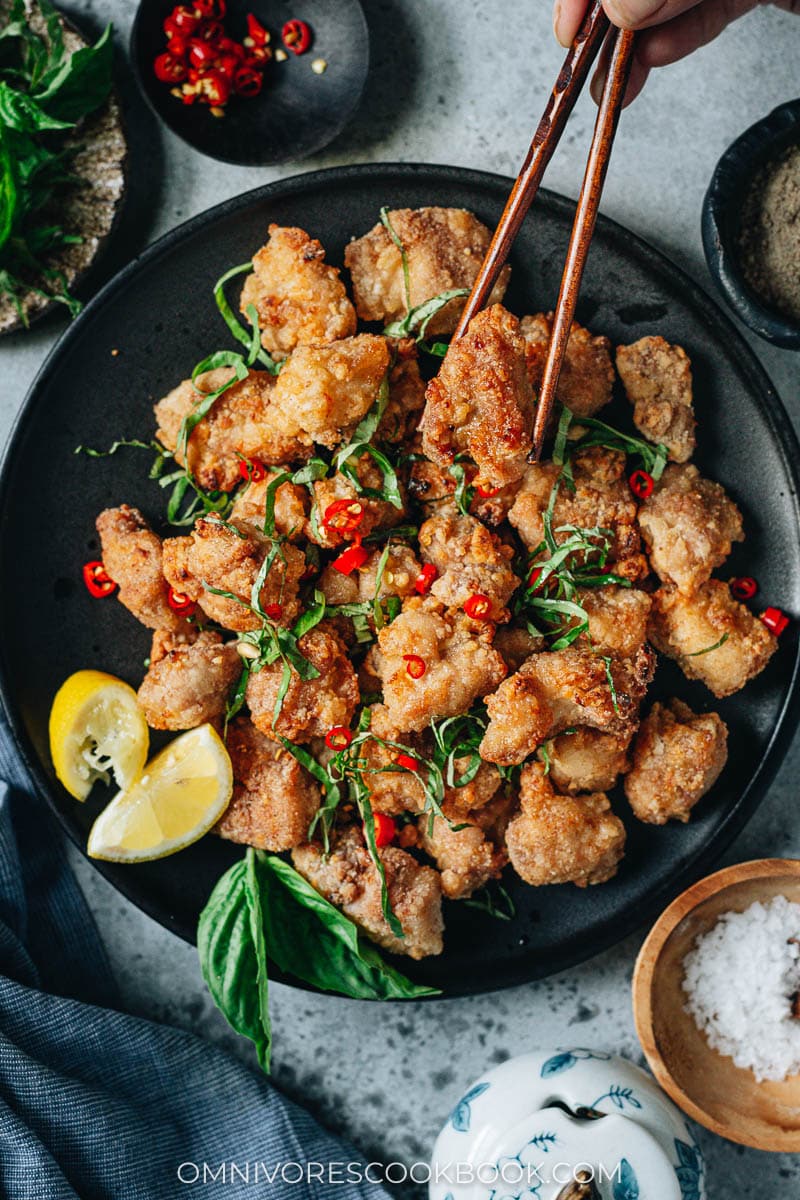 Picking up a crispy chicken bite from a plate