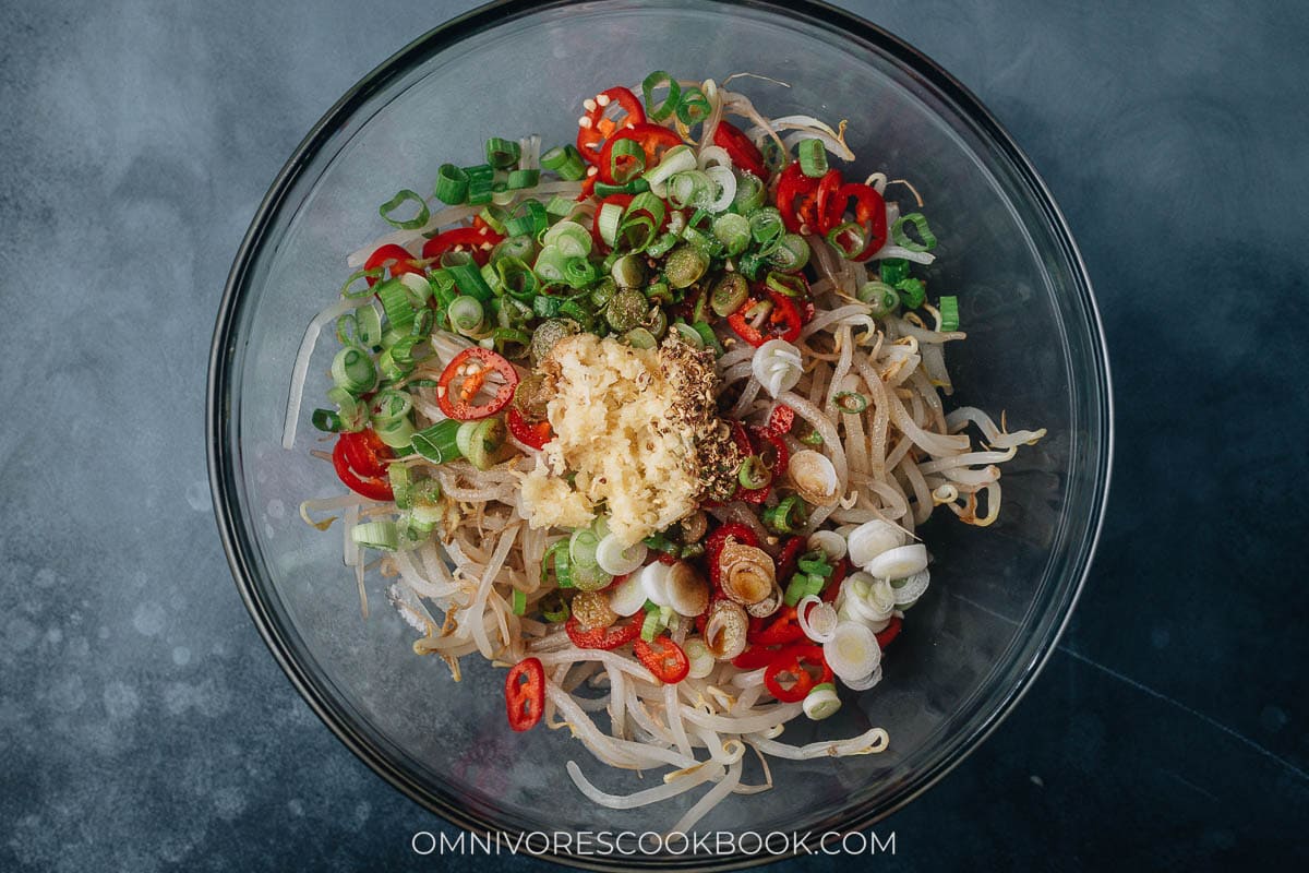 Mixing bean sprouts with aromatics and sauce