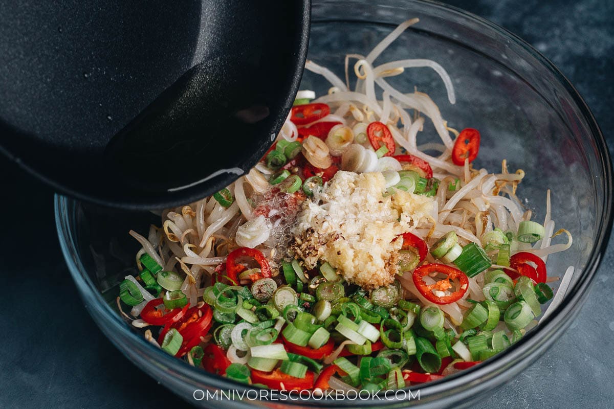 Pouring hot oil over bean sprout salad