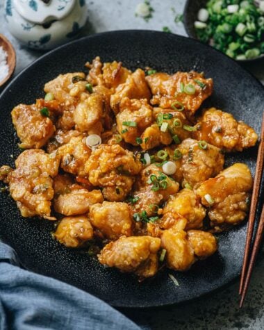 Homemade orange chicken garnished with green onion