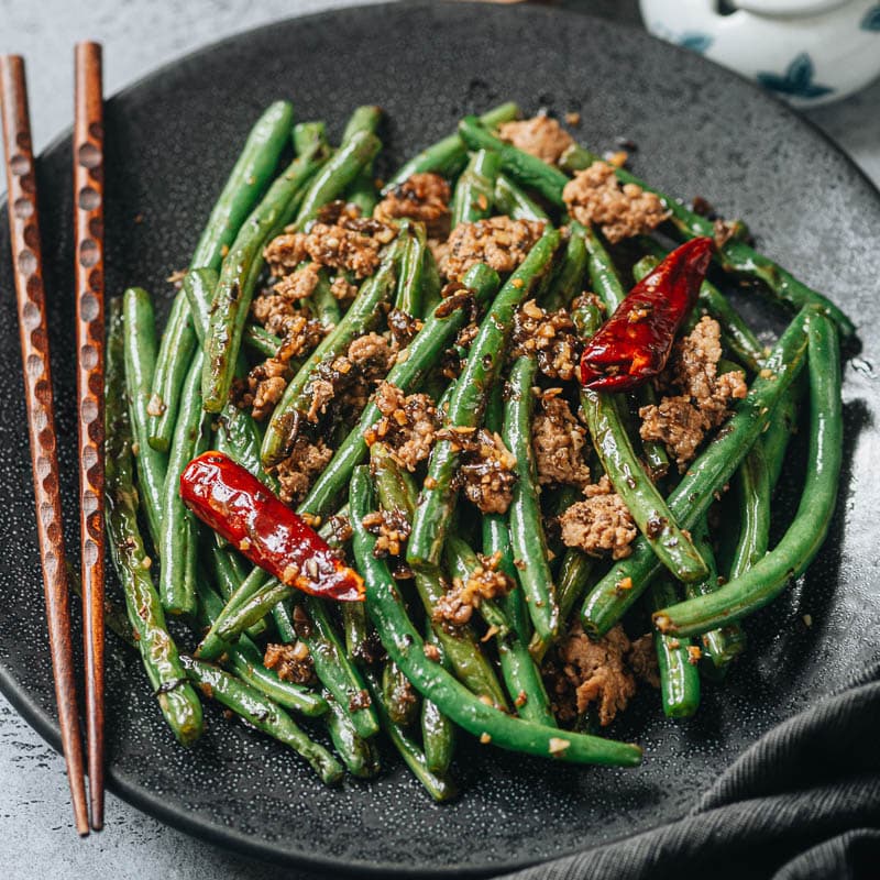 Sichuan dry fried green beans feature blistered green beans tossed with a savory aromatic sauce, making this dish too good to pass up! It&rsquo;s an addictive side dish and substantial enough to serve as a main. {Vegan Adaptable, Gluten Free Adaptable}