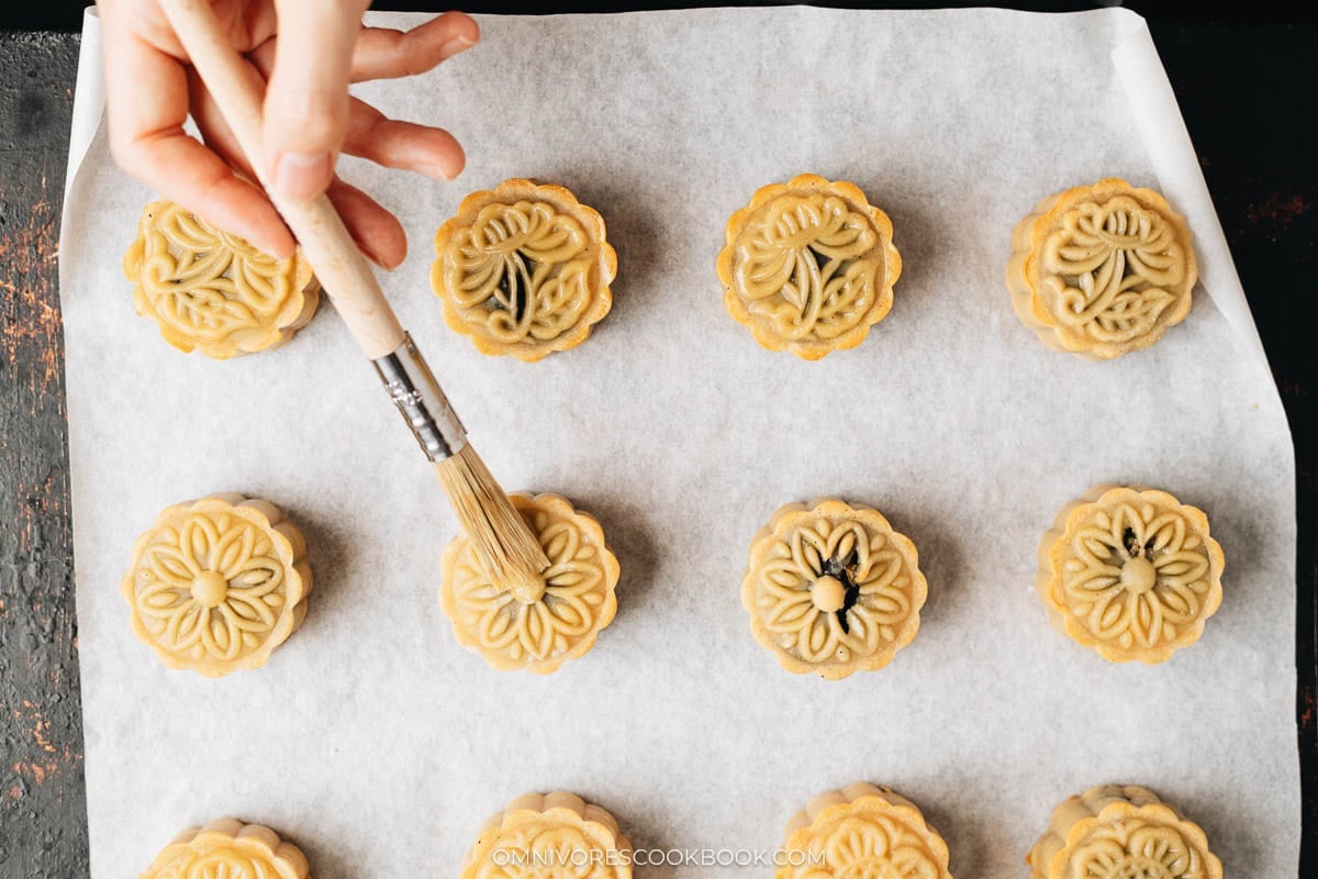 Brush egg wash onto mooncakes