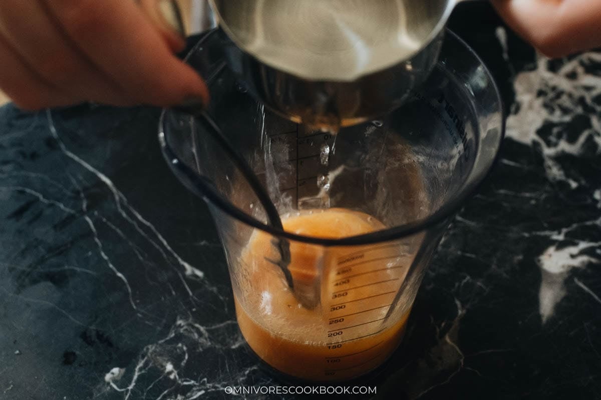adding water to measuring cup with eggs