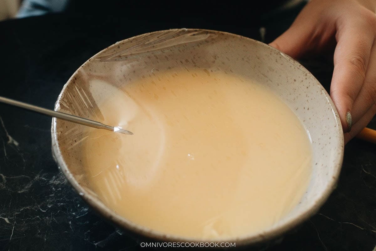 Cover the bowl with plastic wrap and poke holes on top