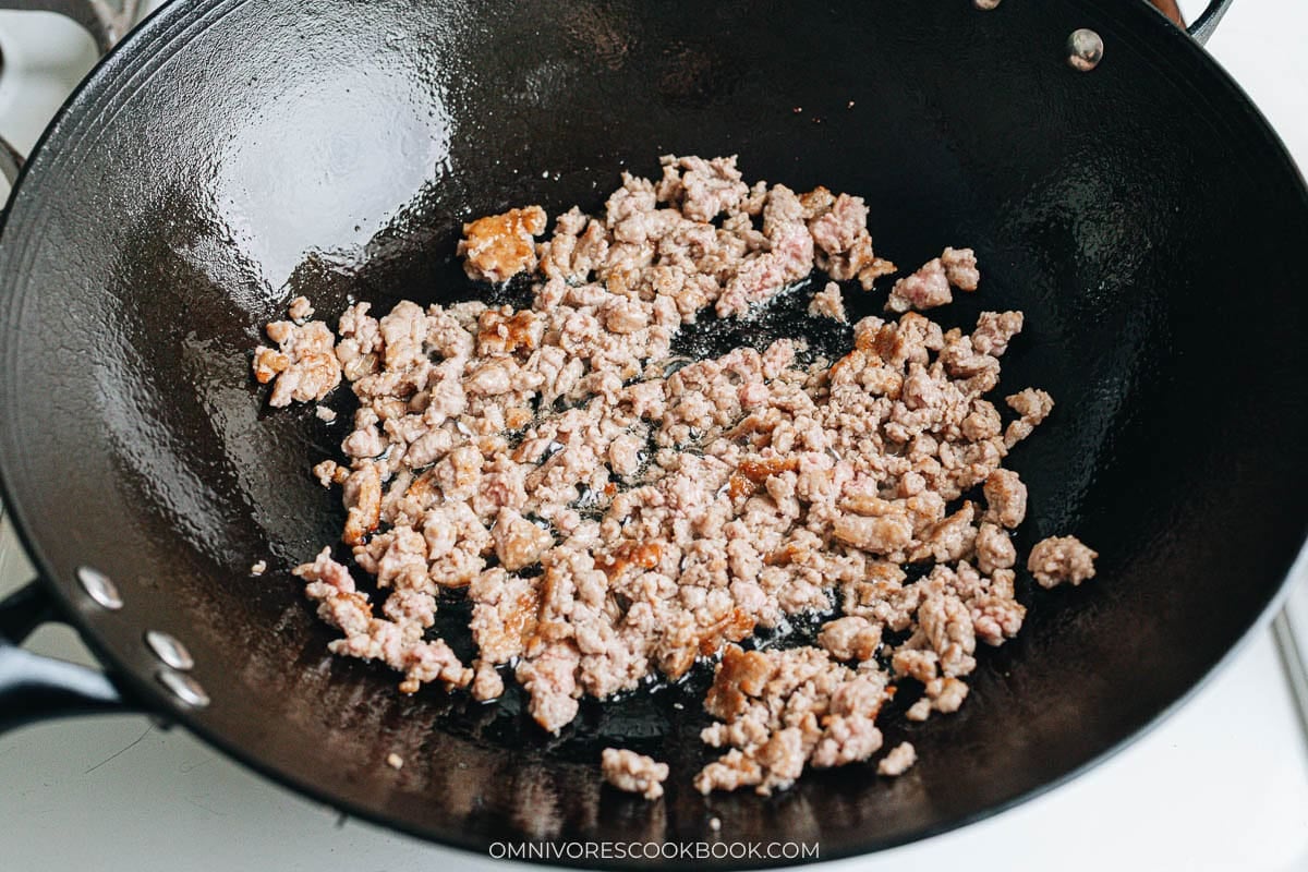Ground meat browning in a wok