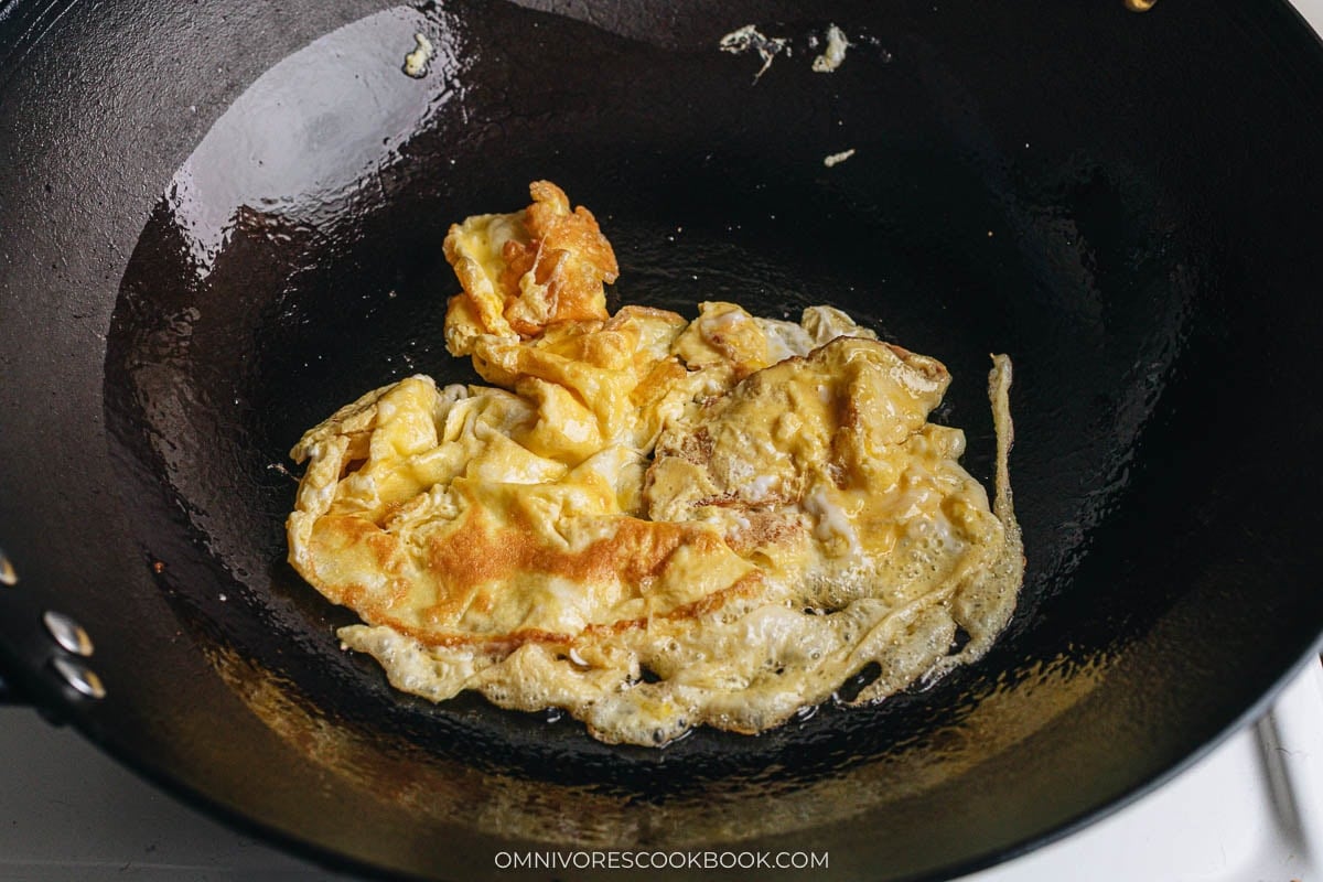 Cooking scrambled egg in a wok.