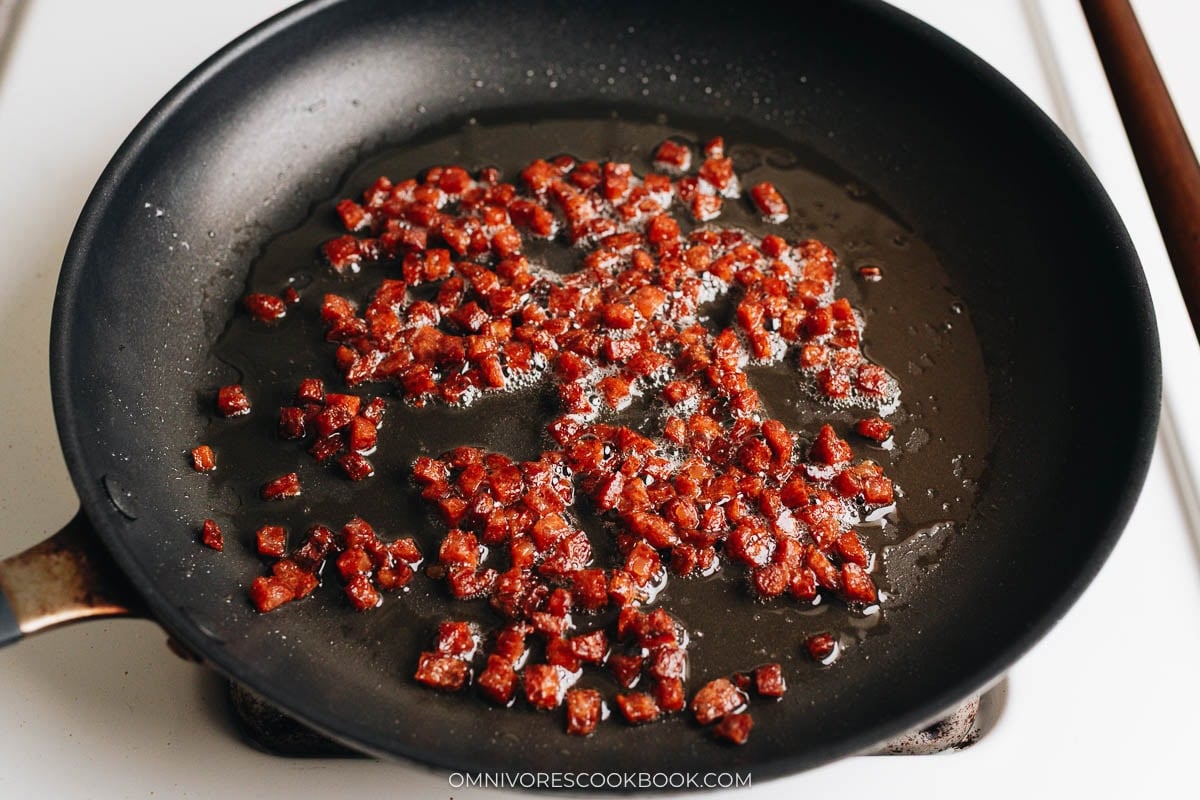 Chinese sausage bits cooking in nonstick skillet