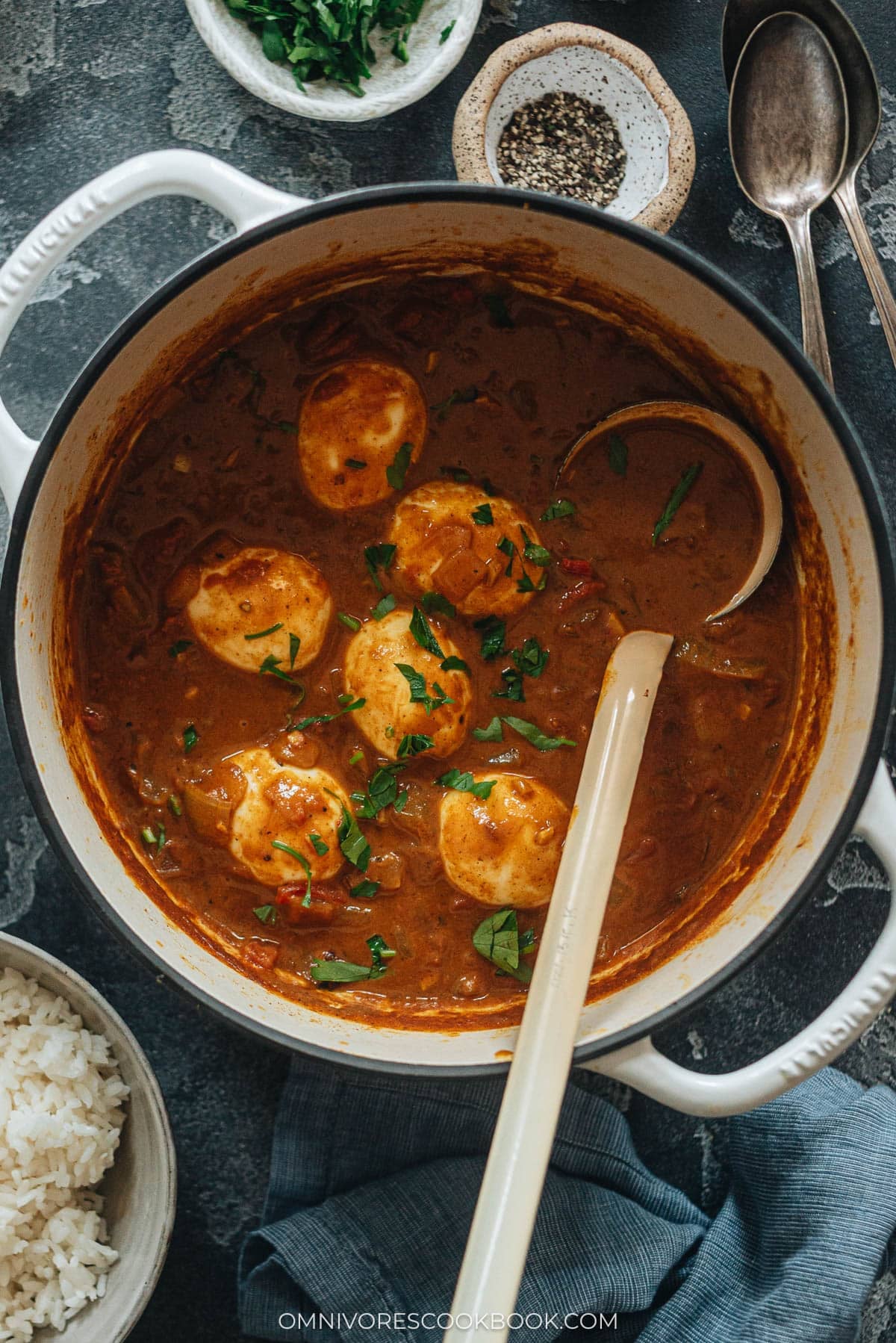 Easy Egg Curry - Tender eggs are smothered in a super rich curry sauce with a tomato and coconut base. The recipe shows you how to cook a tasty curry using minimal ingredients, making it a perfect dish for a busy weekday dinner. {Gluten-Free} Homemade egg curry in a pot