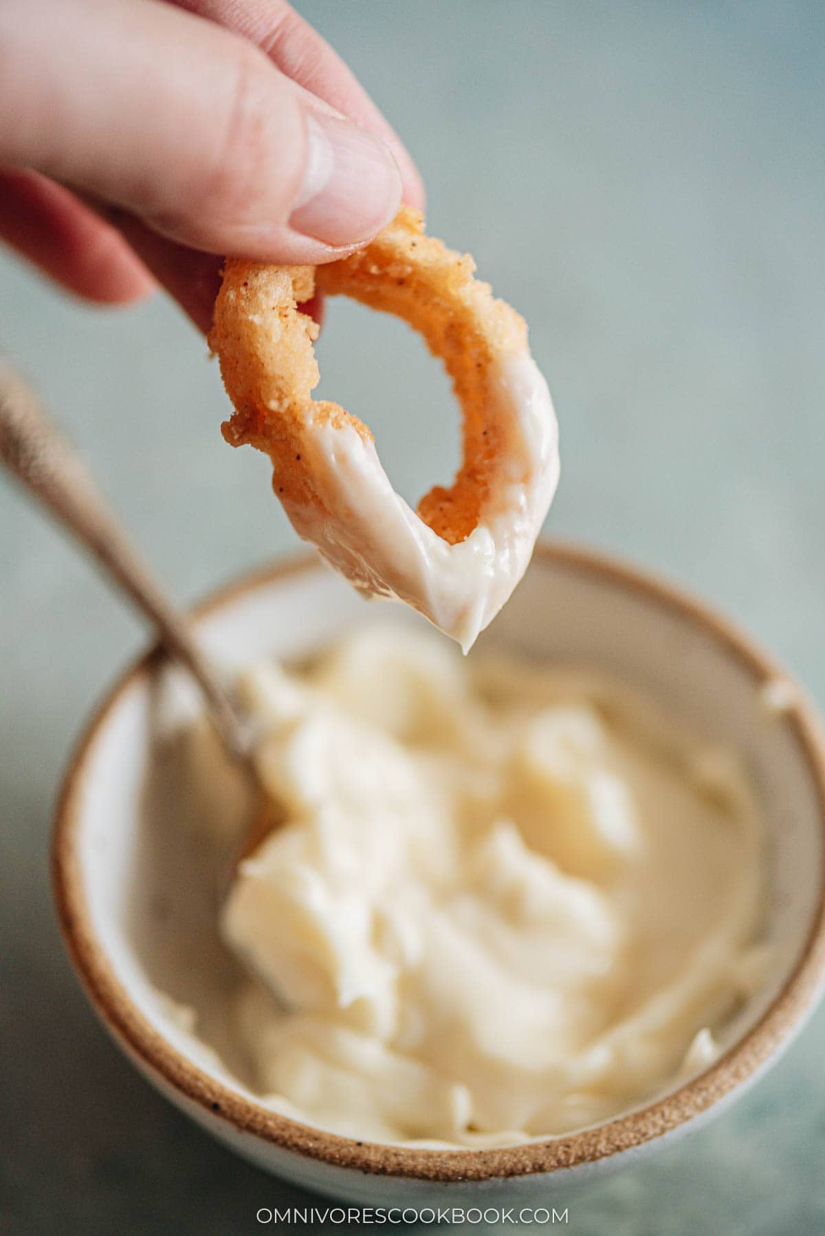 dipping fried squid in a sauce