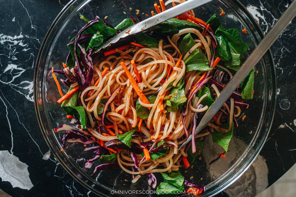 Mixing noodle salad