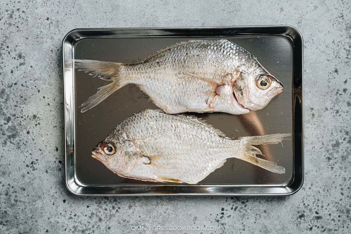 Raw whole sea carp on tray