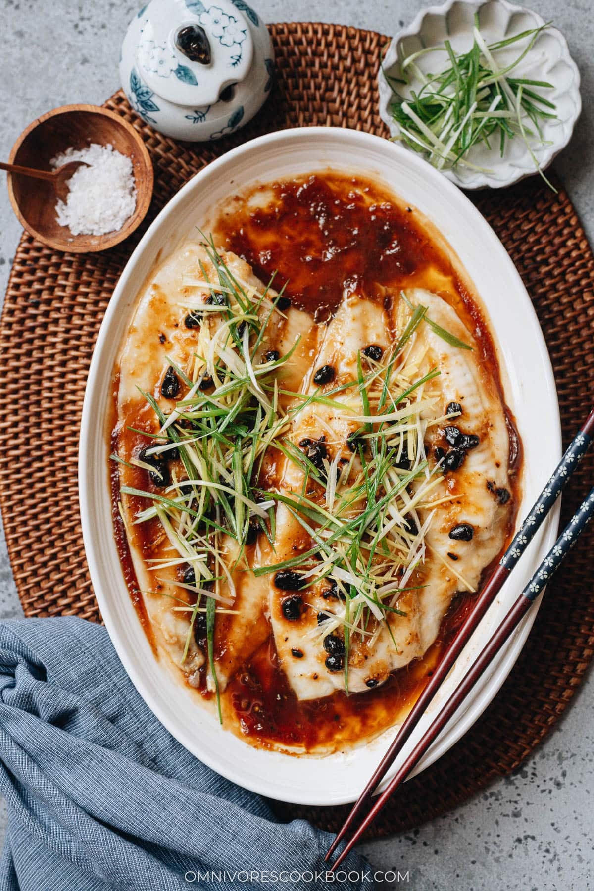 Steamed Fish with Black Bean Sauce serve on a plate with chop sticks

